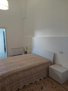 Un dormitorio con una cama y una lámpara. en Casa Vacanze Lu Trappitu, en Magliano