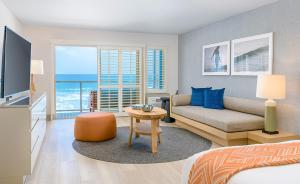 um quarto com uma cama, um sofá e uma televisão em Beach Terrace em Carlsbad