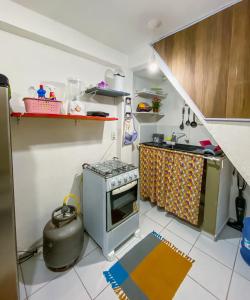 a small kitchen with a stove and a sink at Tiny House in Pipa