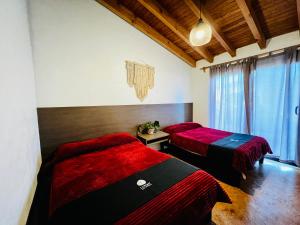 2 posti letto in una camera con lenzuola rosse e nere di Casa Lunah Avandaro a Valle de Bravo