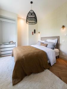 una camera da letto con un grande letto con una coperta marrone di Le Siam a Brest