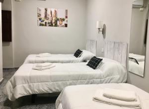 zwei Betten in einem Krankenhauszimmer mit Handtüchern darauf in der Unterkunft Patio de la Plateria in Córdoba