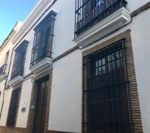 un edificio blanco con puertas y ventanas negras en Patio de la Plateria, en Córdoba