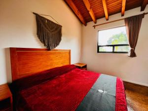 una camera da letto con un letto con una coperta rossa sopra di Casa Lunah Avandaro a Valle de Bravo
