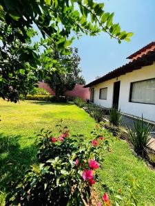 un cortile con fiori rosa e una casa di Casa Lunah Avandaro a Valle de Bravo