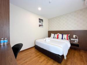 ein Hotelzimmer mit einem großen Bett und einem Schreibtisch in der Unterkunft MII Smile Hotel Penang in George Town