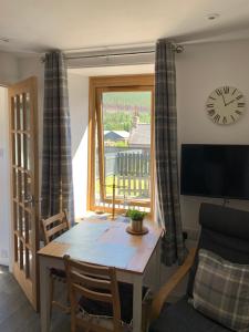 a living room with a table and a window at Pannanich View Cottage, Ballater in Ballater