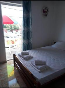 a bedroom with a bed with towels on it at Aris House in Paralia Katerinis