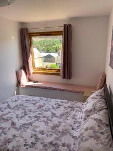a bedroom with a bed and a window at Pannanich View Cottage, Ballater in Ballater