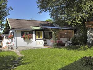 a small white house with a porch and a yard at Haus Deidl in Bad Hindelang