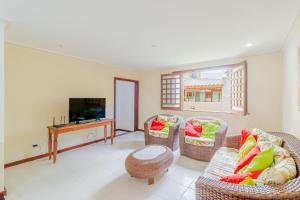 a living room with wicker chairs and a television at GB09 Ótima Casa 6 Quartos a 50m da Praia in Guarajuba