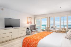 a bedroom with a large bed with a flat screen tv at Beach Terrace in Carlsbad