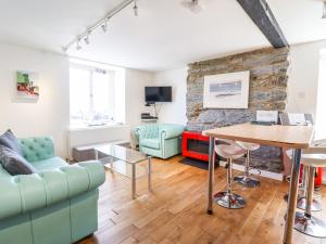 uma sala de estar com um sofá e uma mesa em Harbour Suite em Porthmadog