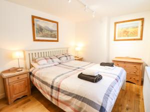 ein Schlafzimmer mit einem großen Bett und zwei Nachttischen in der Unterkunft Harbour Suite in Porthmadog