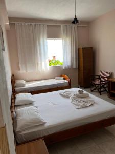 a bedroom with two beds and a window at Emilios house in Dhërmi