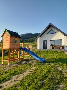 a playground with a slide in front of a house at Domek na Kępie in Sromowce Wyżne