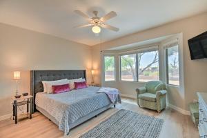 a bedroom with a bed and a ceiling fan and a chair at Welcoming Surprise Home with Patio and Spacious Yard in Surprise