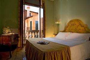 a bedroom with a large bed and a window at Hotel Bonvecchiati in Venice