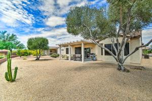 a house with a tree in the middle of a yard at Welcoming Surprise Home with Patio and Spacious Yard in Surprise