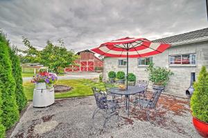 een patio met een tafel en stoelen en een parasol bij Milk Parlor A Vintage-Chic Country Retreat in Snohomish