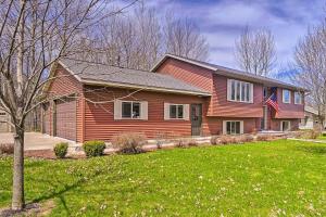 a house with an american flag in a yard at Mosinee Escape with Fire Pit - 1 Mi to River! in Mosinee