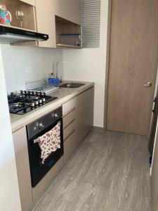 a kitchen with a stove and a counter top at Apartamento en Ricaurte conjunto Puerto Azul Club House in Ricaurte