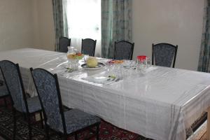 a table with a white table cloth on it at Uz-Anar Guest House in Kochkorka
