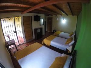 a hotel room with two beds and a window at Finca Hotel La Quinta Porra in Armenia