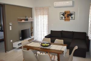uma sala de estar com uma mesa e um sofá preto em VIRGIN ROCKs APARTMENT 2 em Kalabaka