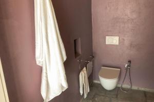 La salle de bains est pourvue d'un rideau de douche blanc et de toilettes. dans l'établissement Agriturismo Cascina Cornelli, à Sassello