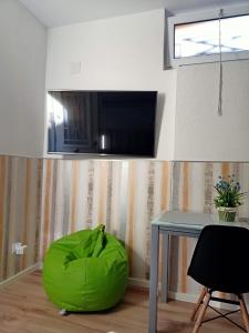 ein Wohnzimmer mit einem Stuhl mit grünen Bohnen und einem Tisch in der Unterkunft Ángeles home in El Vendrell