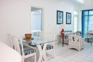 comedor con mesa de cristal y sillas en Sunset Cove - Vacation In Paradise!, en Nassau