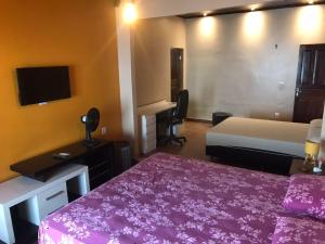 a hotel room with two beds and a flat screen tv at Casa LB com estacionamento privado in Boa Vista