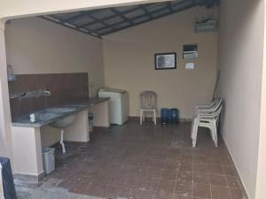 Zimmer mit 2 Stühlen, einem Tisch und einem Waschbecken in der Unterkunft Casa LB com estacionamento privado in Boa Vista