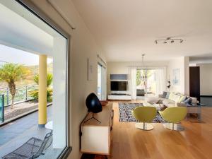 een woonkamer met een bank en een tafel en stoelen bij Estrela do Mar - by LovelyStay - Lovely, Sun Filled Villa in Calheta