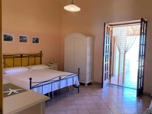 1 dormitorio con 1 cama y puerta que da a un patio en Casa Nina - Villetta indipendente con ampio terrazzo panoramico, en Malfa