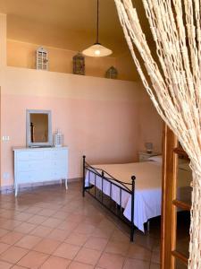 1 dormitorio con 1 cama con tocador y espejo en Casa Nina - Villetta indipendente con ampio terrazzo panoramico, en Malfa