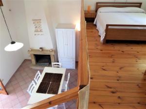 1 dormitorio con 1 cama, mesa y sillas en Casa Nina - Villetta indipendente con ampio terrazzo panoramico, en Malfa