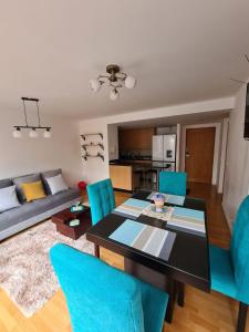 uma sala de estar com uma mesa e cadeiras azuis em Rep del Salvador, Quito 1-bedroom condo with parking and Netflix em Quito