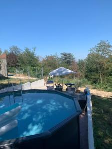 a swimming pool with a table and chairs and an umbrella at Ca' degli Ovi in Valenza
