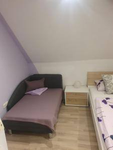 - une petite chambre avec 2 lits et une table de nuit dans l'établissement Ella's Wolke Appartements - EW3, à Zweibrücken 2 autres photos