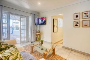 a living room with a couch and a table at Hampton Collection - Trendy 2 Sleeper Apartment with Pool in Durban