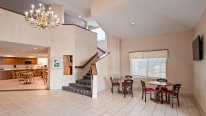 ein Wohnzimmer mit einer Treppe und ein Esszimmer in der Unterkunft Charlevoix Inn & Suites SureStay Collection by Best Western in Charlevoix