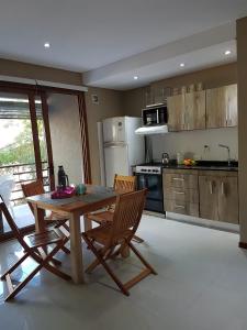 a kitchen with a wooden table and chairs in it at Arenas 1 in Valeria del Mar