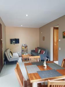 a living room with a table and a blue couch at Arenas 1 in Valeria del Mar