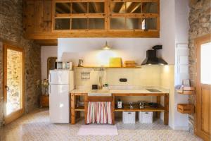 una cucina con frigorifero bianco e bancone di El Mas de Sant Vicenç - apartamentos rurales ad Arsèguel