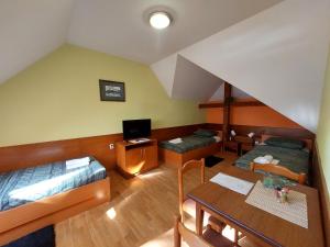 a attic room with two beds and a table at Craft Beer Bar Rooms in Varaždin