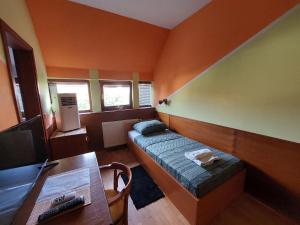 Habitación pequeña con cama, escritorio y TV. en Craft Beer Bar Rooms en Varaždin