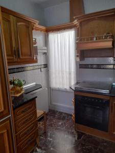 a small kitchen with a stove and a window at Piso en Montillana 