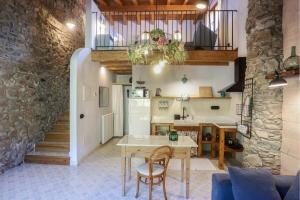 a kitchen and living room with a table and chairs at El Mas de Sant Vicenç - apartamentos rurales in Arsèguel